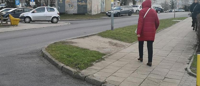 Piesi przechodzą przez wydeptany trawnik